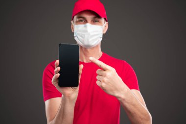 Akıllı telefonu işaret eden neşeli kurye