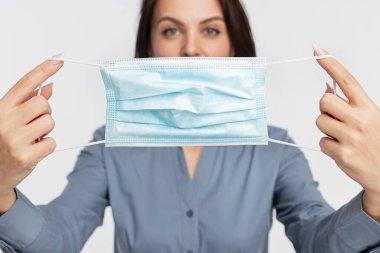 Kadın cerrahi maske takıyor.