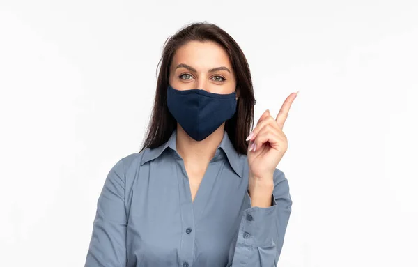 Vrouw met beschermend masker wijst omhoog — Stockfoto