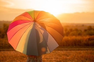 Gün batımında el sallayan isimsiz bir bayan.