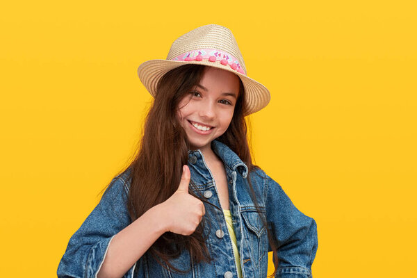 Радостная девушка со скейтбордом показывает большой палец вверх
