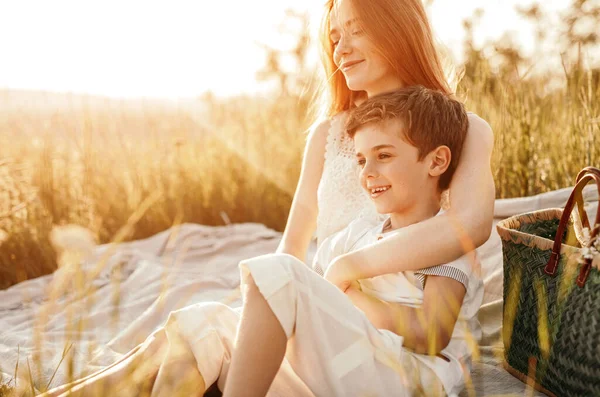 Jonge vrouw knuffelen kleine broer tijdens picknick — Stockfoto