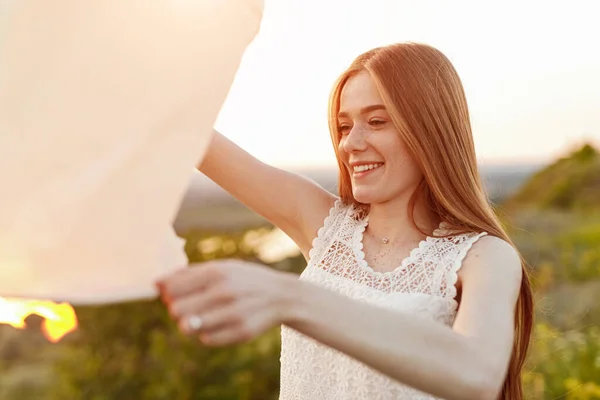 Mujer feliz lanzando linterna de cielo — Foto de Stock