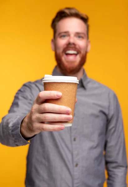 Cara feliz oferecendo bebida quente para câmera — Fotografia de Stock