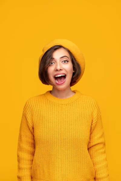 Mujer sorprendida en traje amarillo mirando a la cámara — Foto de Stock