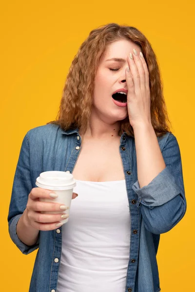 Mujer cansada con café para ir bostezando —  Fotos de Stock