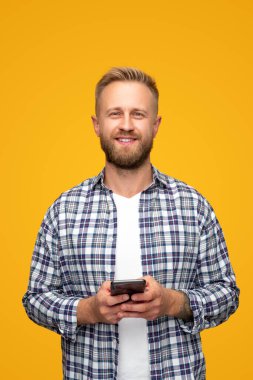 Modern adam akıllı telefon kullanıyor ve gülümsüyor.