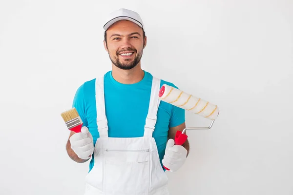 Positive craftsman with painting tools looking at camera — Stock Photo, Image