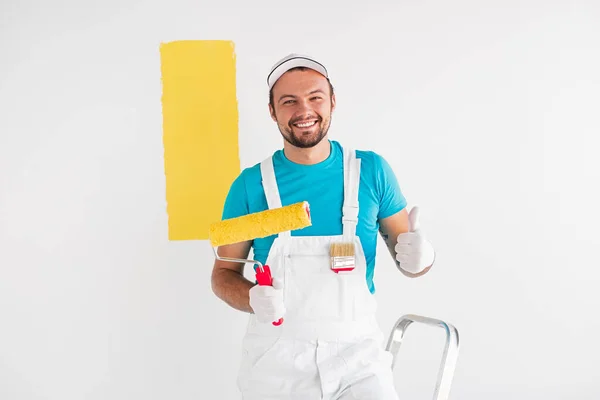 Hombre feliz pintando la pared y mostrando signo de aprobación — Foto de Stock