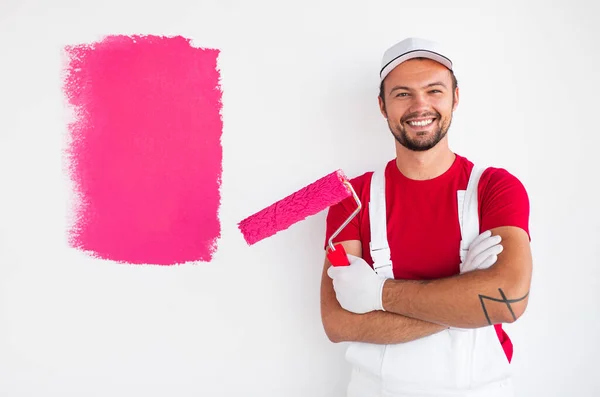 Pintor positivo de pie cerca de la muestra en la pared — Foto de Stock