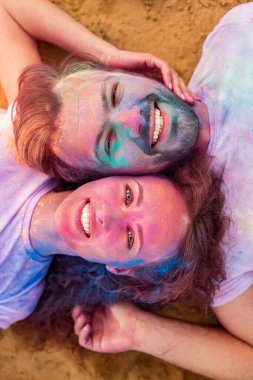 Boya tatilinde gülümseyen ve plajda uzanan çift