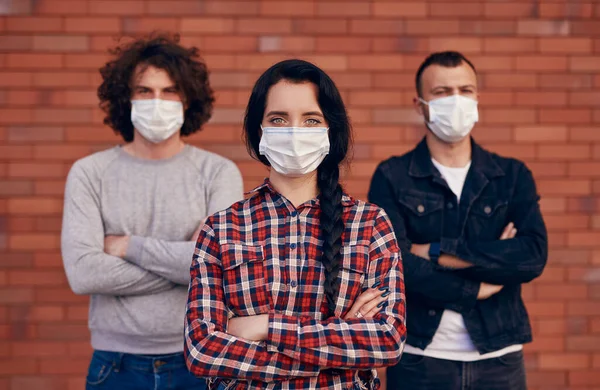 Woman in medical mask with male friends — Stock Photo, Image