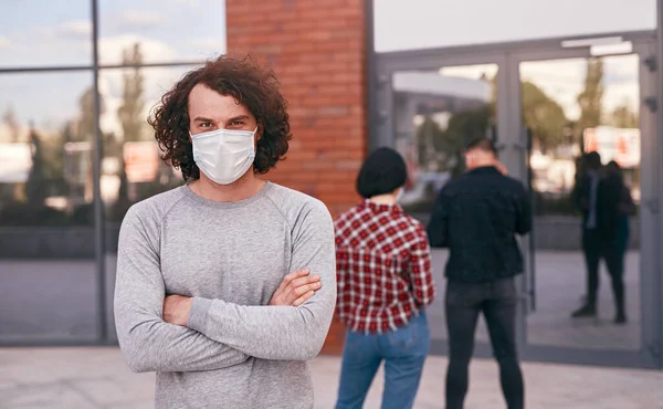 Uomo sicuro in maschera in piedi in coda — Foto Stock