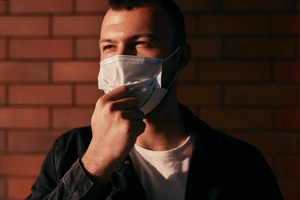 Сучасний чоловік коригує медичну маску — стокове фото