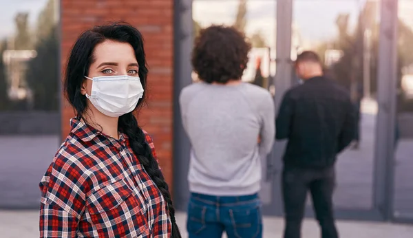 Mujer enmascarada manteniendo la distancia social en cola —  Fotos de Stock