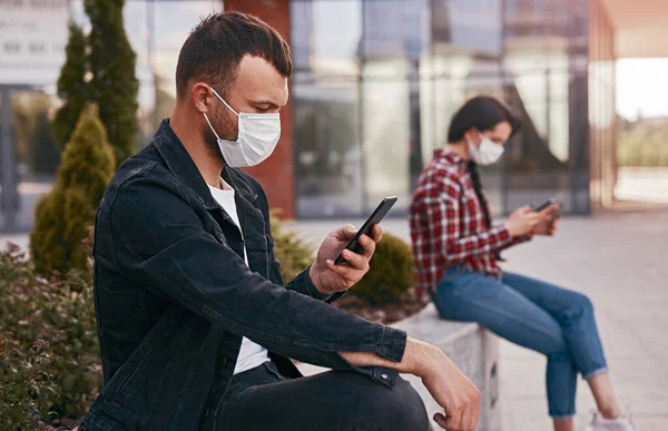 Man using smartphone away from woman