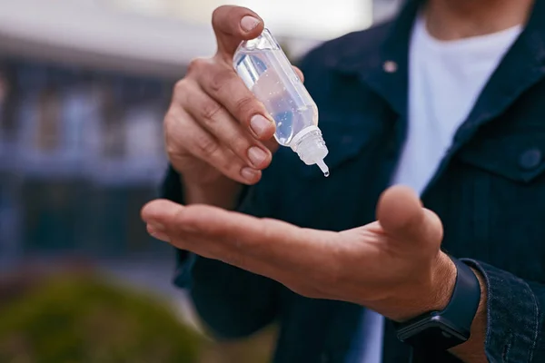 Crop man disinfecting hands on street — Stock Photo, Image