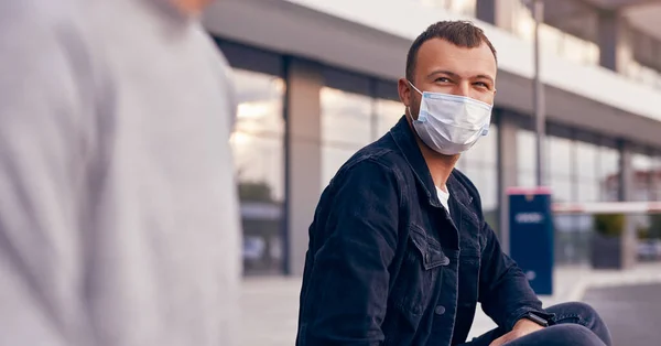 Jeune homme avec un ami se reposant dans la rue pendant l'épidémie — Photo