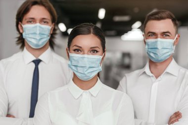 Confident business team in medical masks clipart
