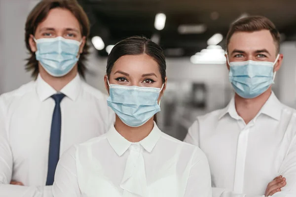 Tıbbi maskeli, kendine güvenen iş adamları.