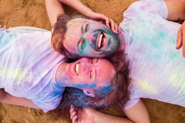 Heyecanlı çift boya festivali sırasında sahilde takılıyor.