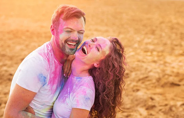 Loving couple laughing at joke during paint party