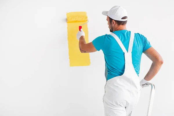 Maler bemalt Wand in gelber Farbe — Stockfoto