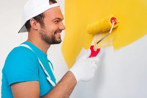 Alegre artesano pintando pared con rodillo — Foto de Stock