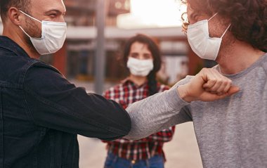 Erkekler birbirlerini dirsekleriyle selamlıyorlar.