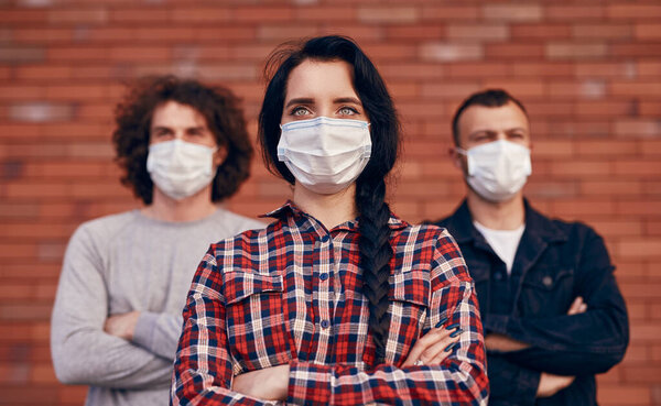 Millennial woman and men in protective masks during coronavirus pandemic Royalty Free Stock Images