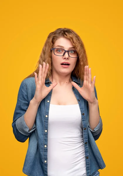 Mujer joven asombrada haciendo gestos y mirando a la cámara — Foto de Stock