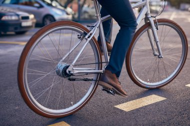 Ekin adam şehirde bisiklet sürüyor.