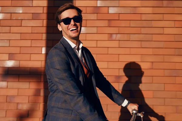 Feliz hombre de negocios con bicicleta contra la pared de ladrillo —  Fotos de Stock
