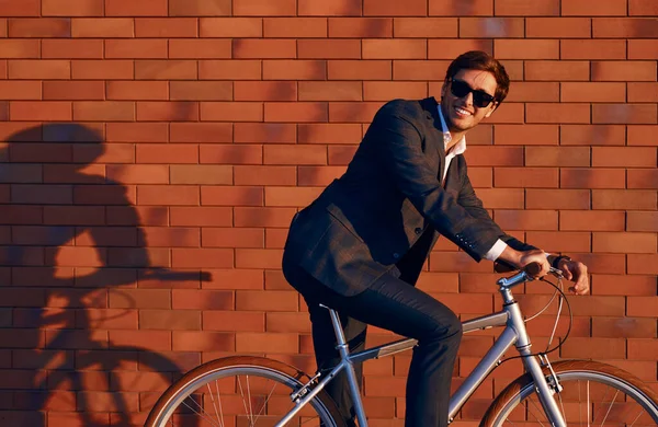 Hombre de negocios alegre en traje de moda montar en bicicleta —  Fotos de Stock