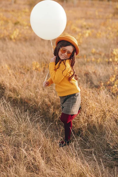 Criança elegante com balão em campo seco — Fotografia de Stock