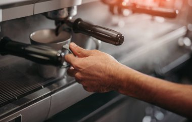 Barista kahve makinesinde taze kahve hazırlıyor.