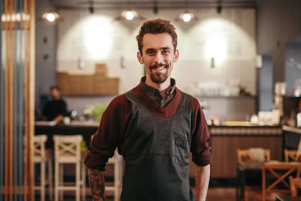 Barista sonriente de pie en la cafetería moderna — Foto de Stock