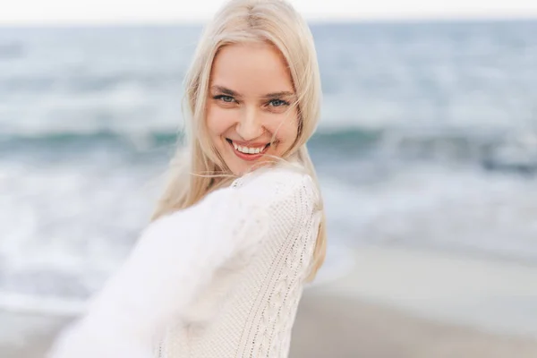 Красивая женщина улыбается возле океана — стоковое фото