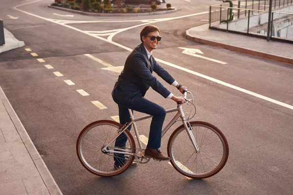 Бизнесмен переходит дорогу на велосипеде — стоковое фото