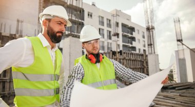 İnşaat işçileri inşaat planını tartışıyor