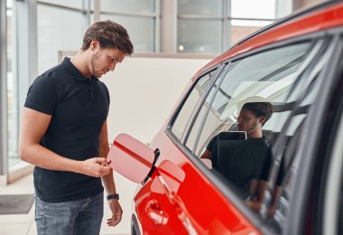 Ciddi bir adam yakıt deposunu kontrol ediyor.