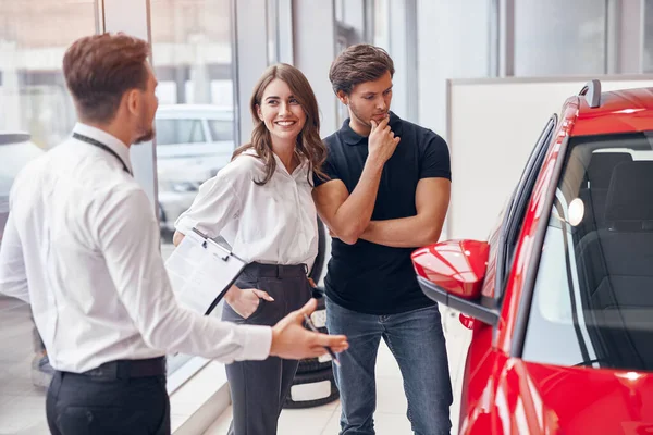 Gerente ajudando casal a escolher carro — Fotografia de Stock