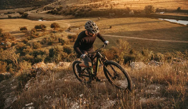 Homem com mountain bike escalada colina — Fotografia de Stock