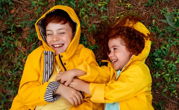 Feliz jengibre niños jugando en el suelo del bosque —  Fotos de Stock