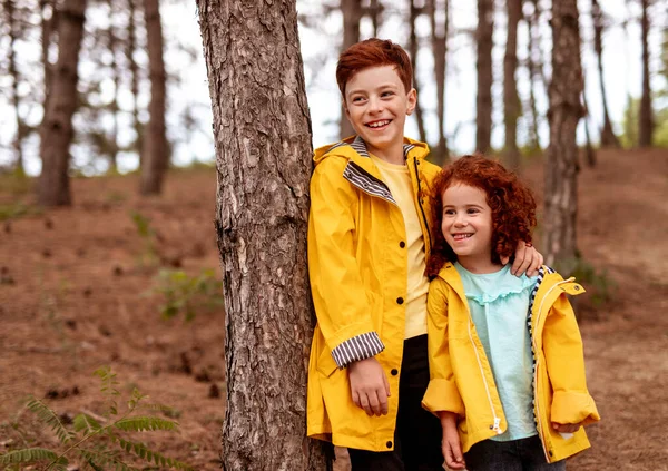 Lyckliga syskon står nära trädet — Stockfoto