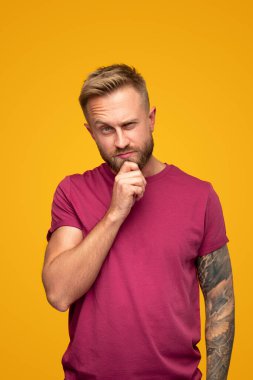 Düşünceli adam kameraya bakıyor.