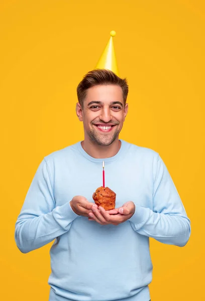 Jovem feliz com muffin festivo — Fotografia de Stock