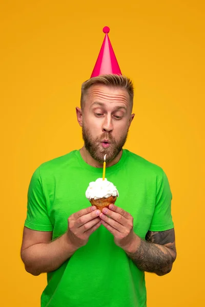 幸せな男吹きアウトキャンドル上のカップケーキ — ストック写真