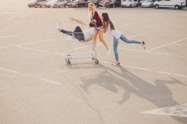 Hippi arkadaşlar alışveriş arabasıyla eğleniyor.