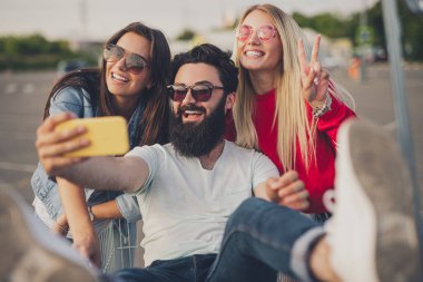 Mutlu arkadaşlar alışveriş yaparken selfie çekiyorlar.